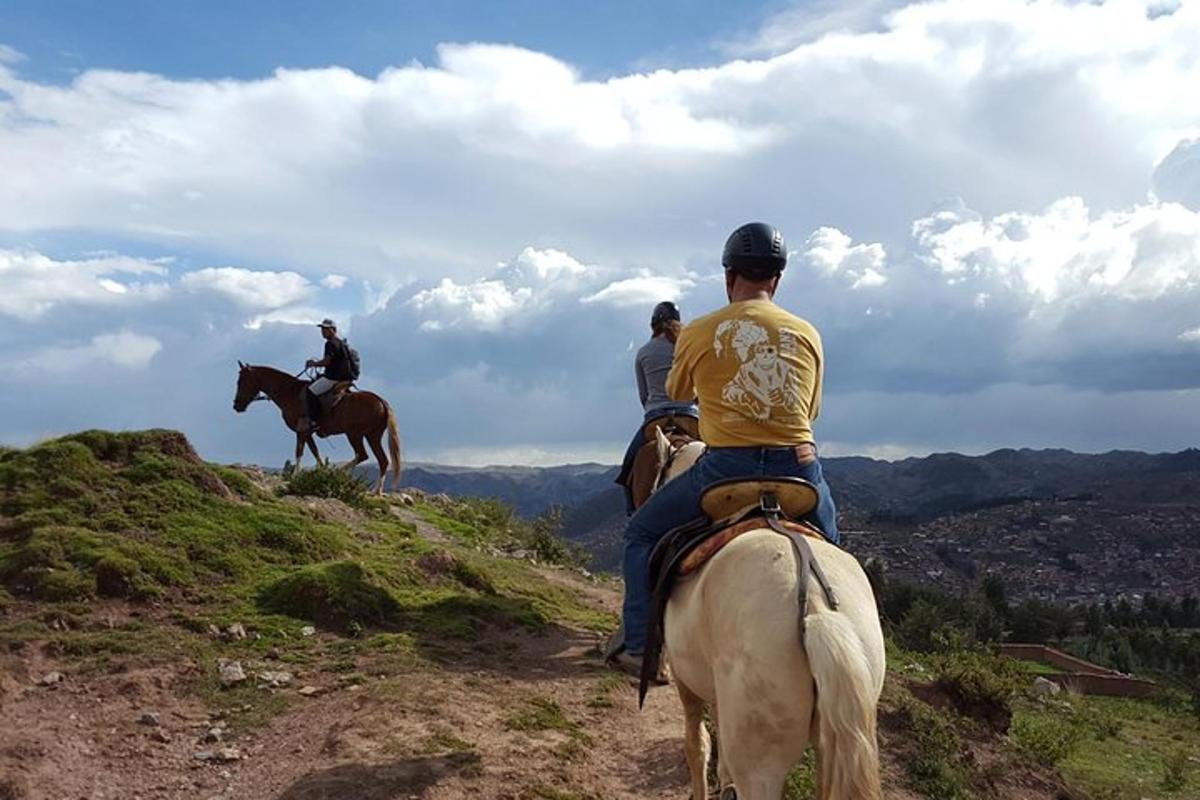 un grup de persones muntant a cavall en un turó
