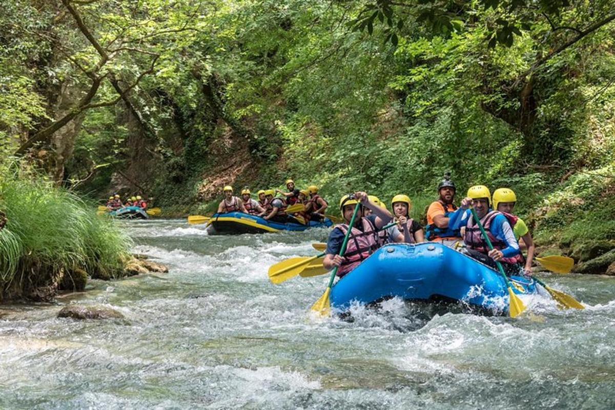 skupina ľudí splavuje rieku na raftoch