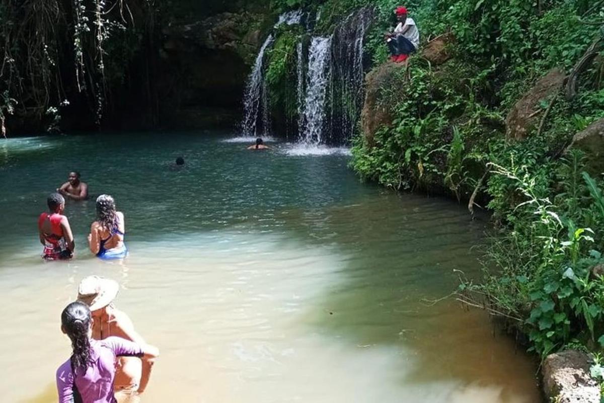 un gruppo di persone in acqua vicino a una cascata