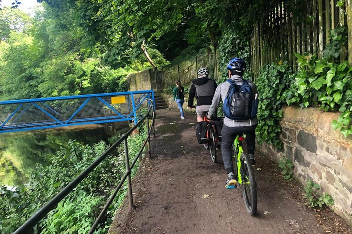 două persoane mergând cu bicicleta pe o potecă de pământ