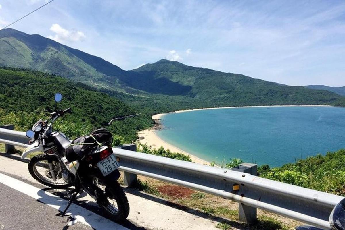 una moto parcheggiata su una strada vicino a una spiaggia