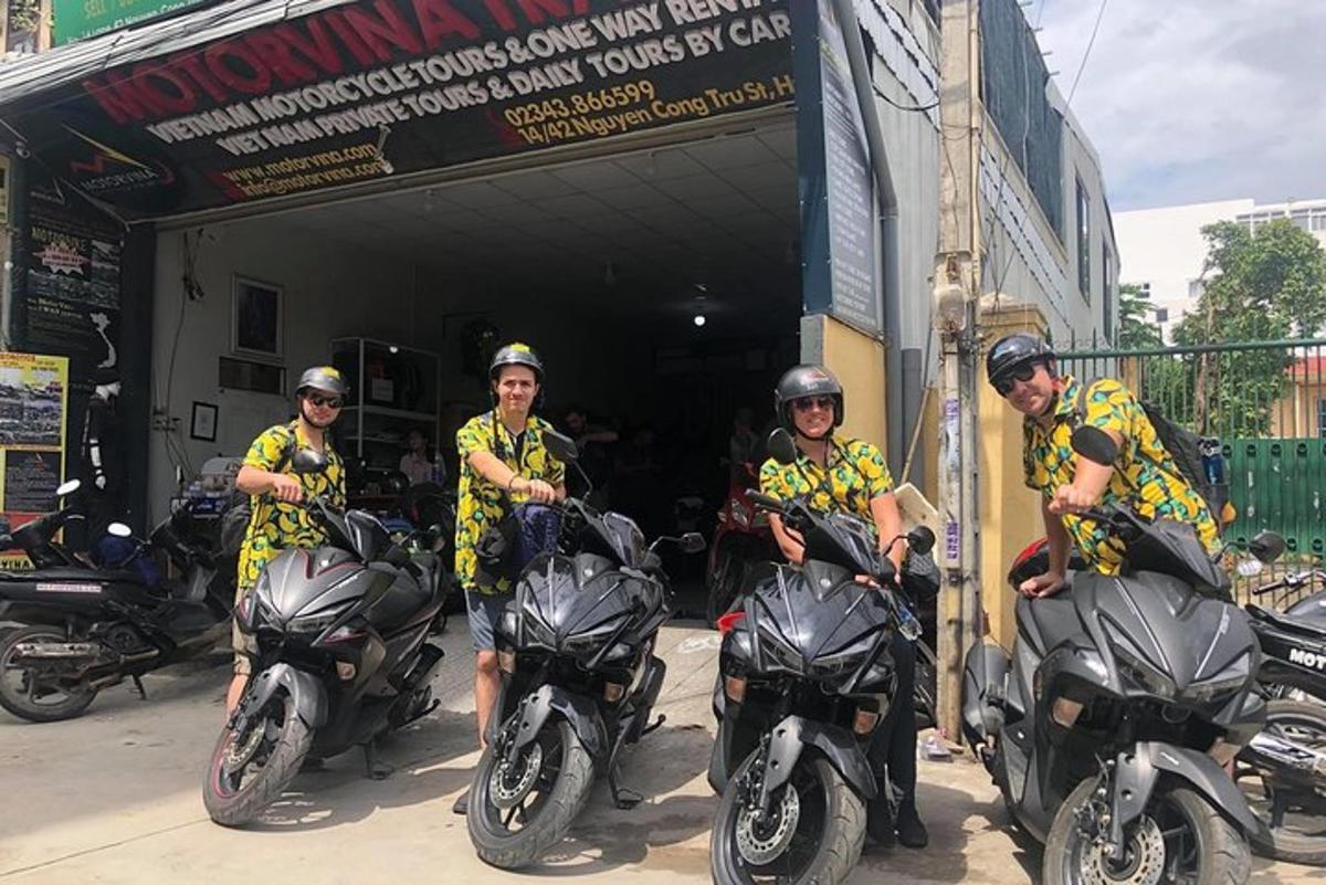 Μια ομάδα ανδρών που κάθονται σε μοτοσικλέτες μπροστά από ένα γκαράζ