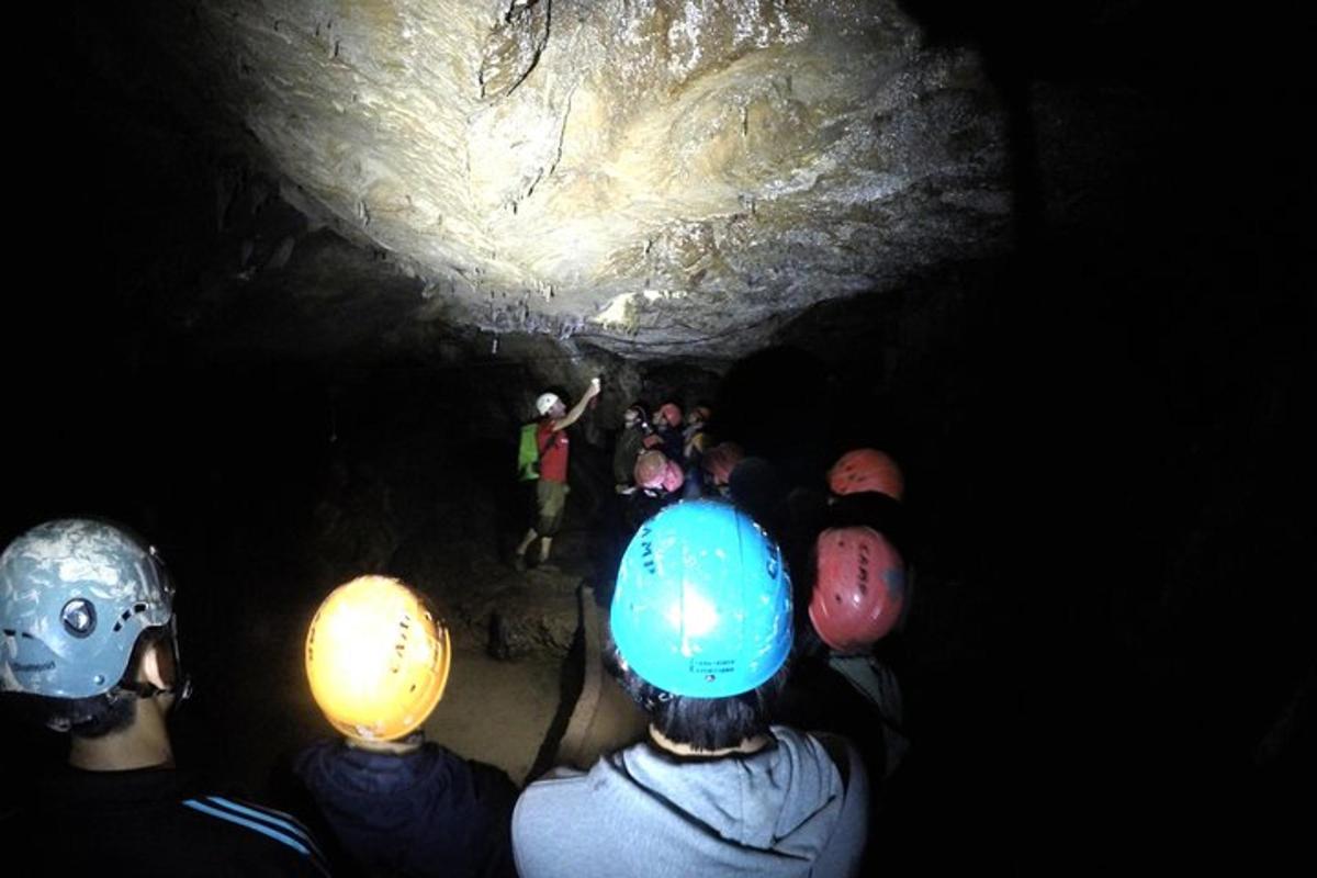 skupina lidí stojící v temné jeskyni