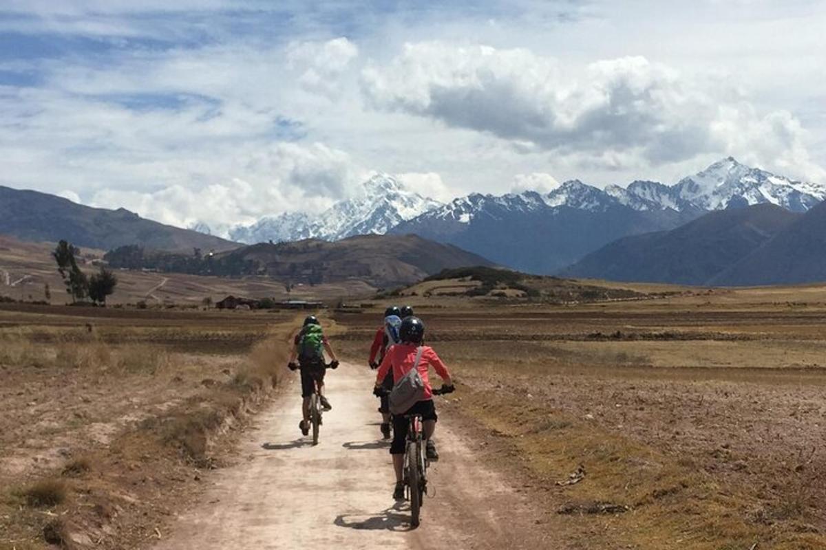 a group of people riding bikes down a dirt road