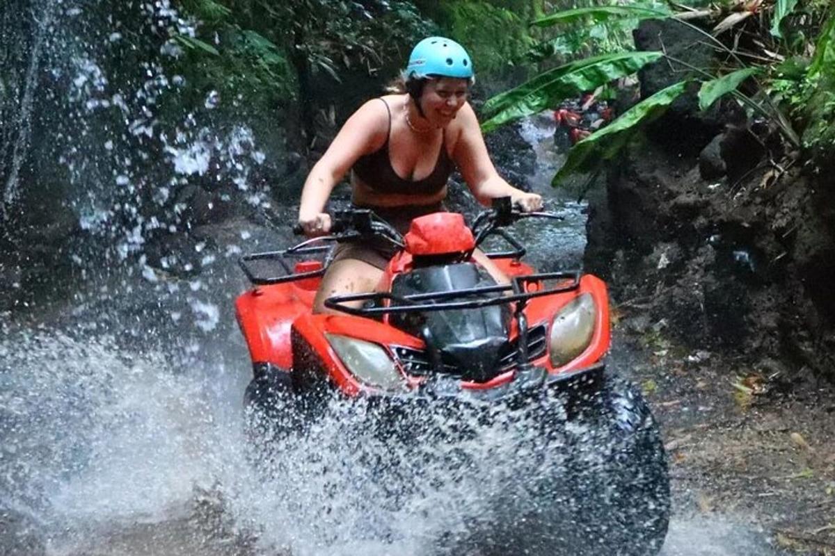 o femeie care merge cu un ATV printr-o cascadă