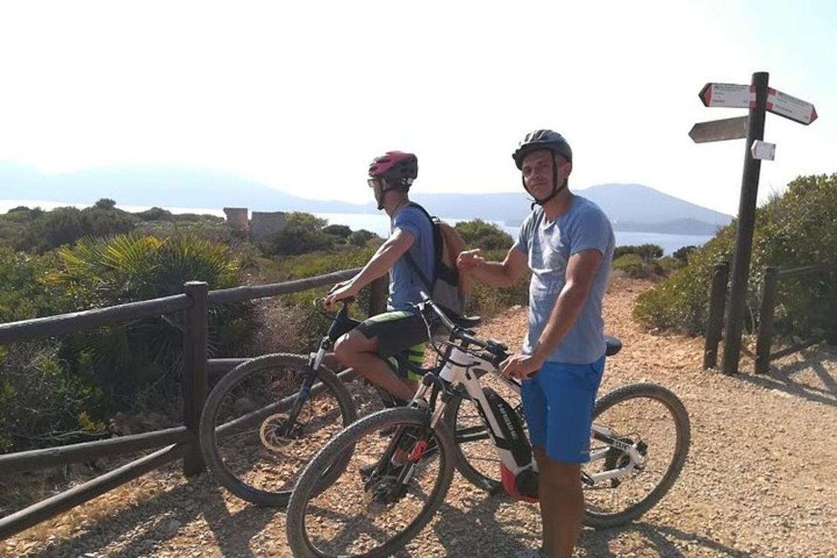 two people standing with their bikes on a trail
