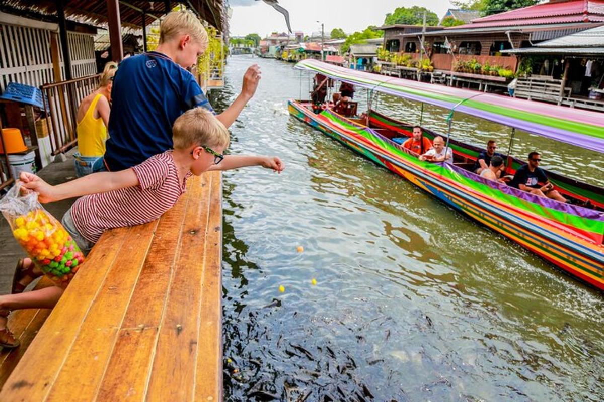 Un hombre y un niño pequeño sentados en un muelle de madera junto a un barco.