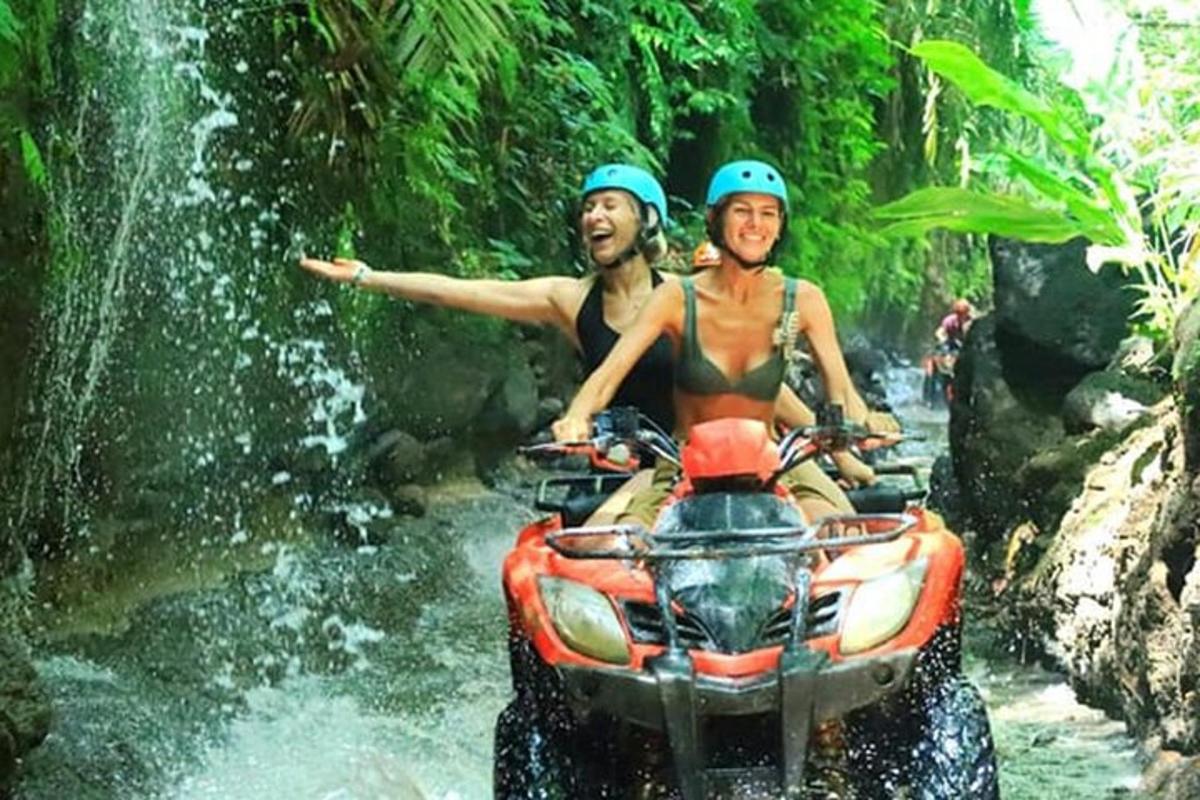 dua orang mengendarai kendaraan roda empat melewati sungai