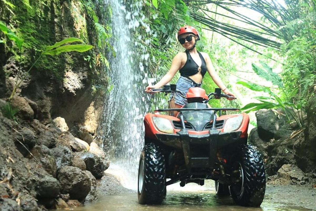 o femeie pe un ATV în fața unei cascade