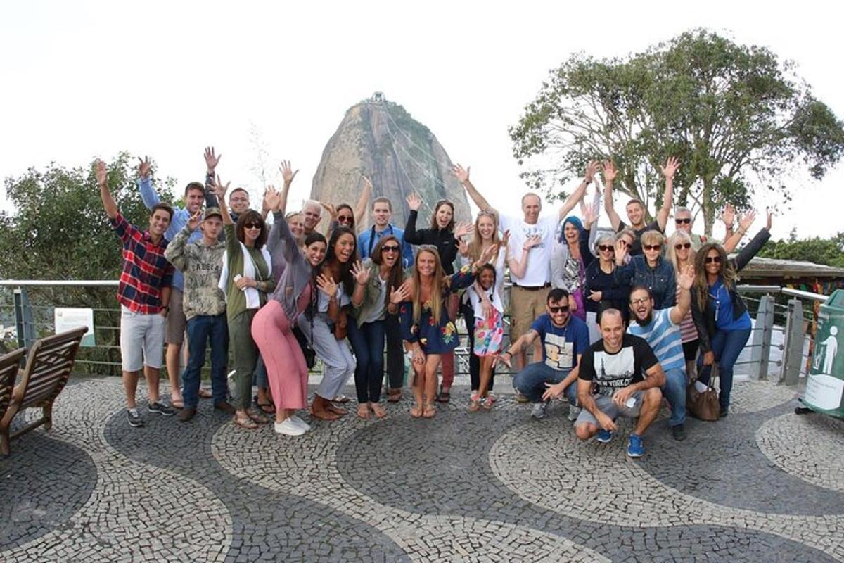 Un grupo de personas posando para una foto frente a una roca.