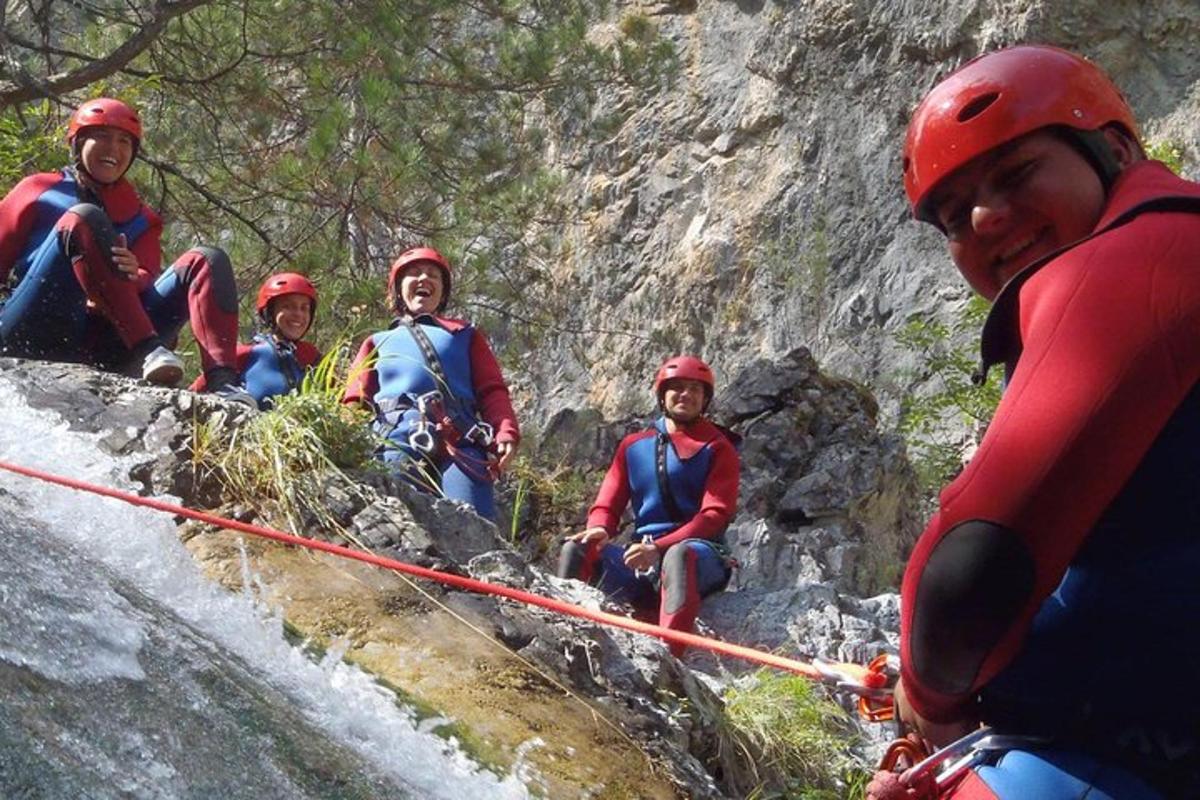 a group of people sitting on the side of a river