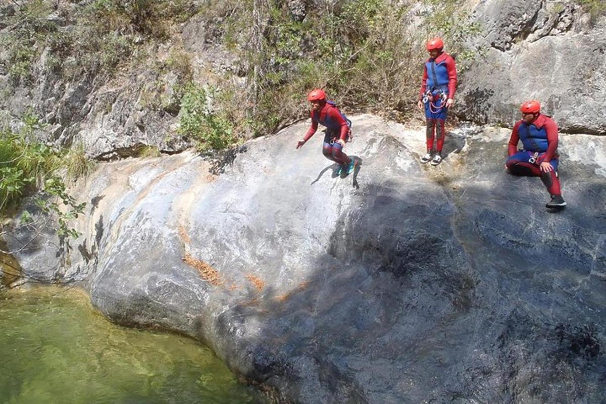 a group of people on a rock near a river