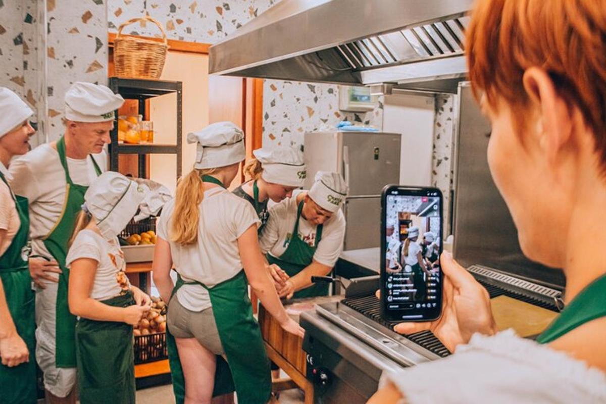 skupina kuchařů v kuchyni s mobilním telefonem