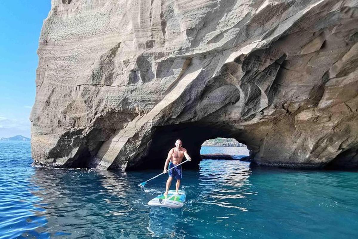 moški na deski za veslanje pred jamo