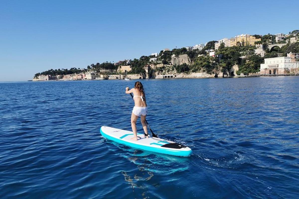 kona stendur á brimbretti í vatninu