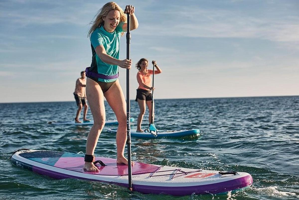 una donna in piedi su una tavola da paddle in acqua