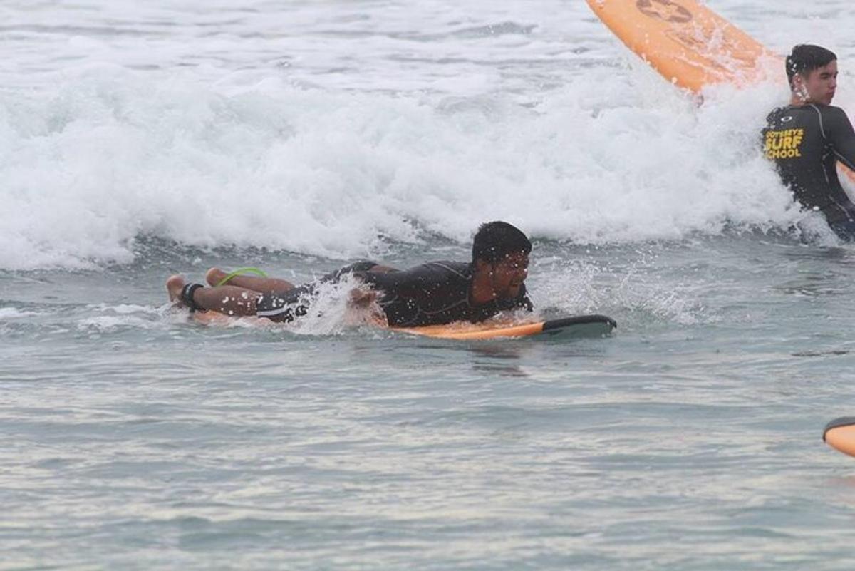 een persoon die op een surfplank in de oceaan ligt