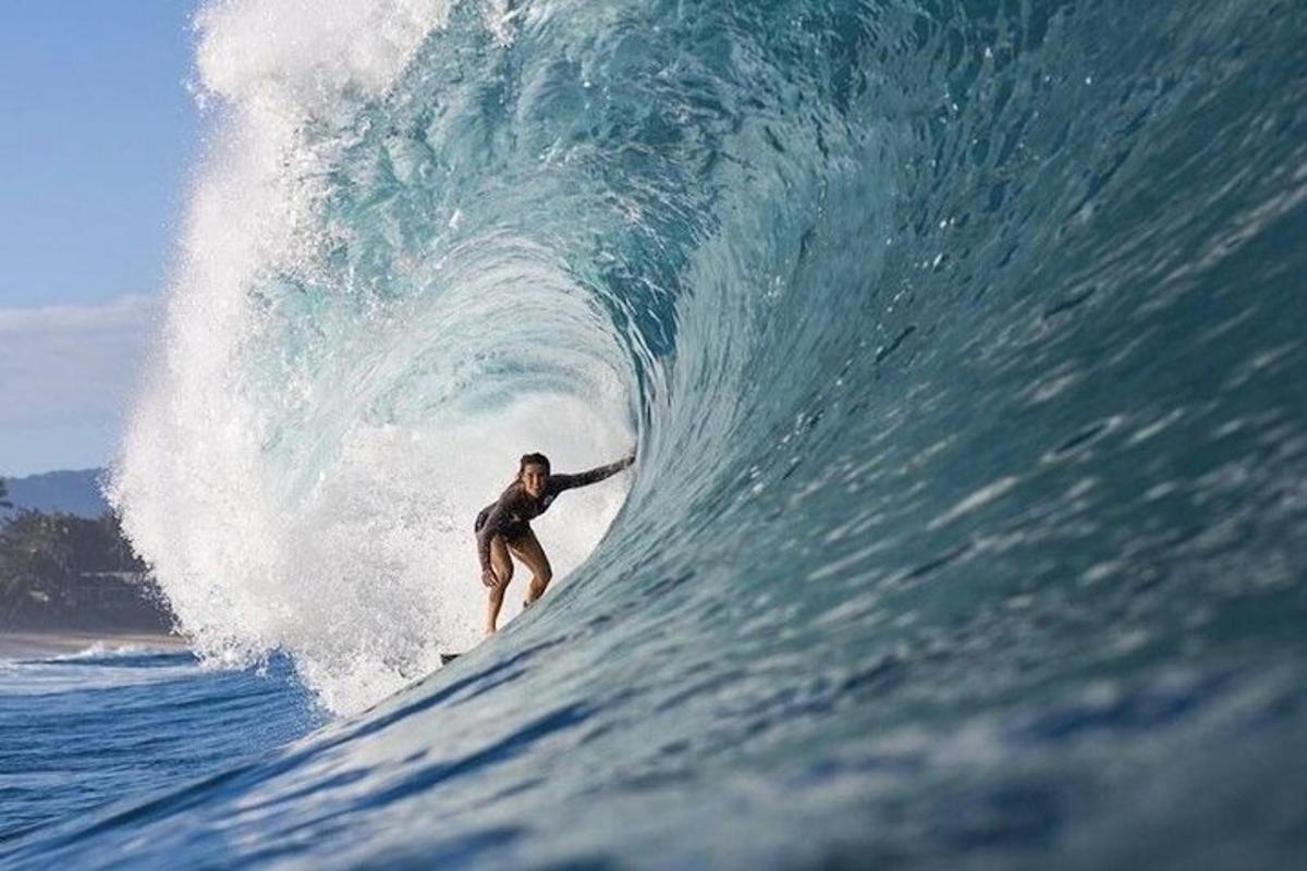een man die op een surfplank in de oceaan op een golf rijdt