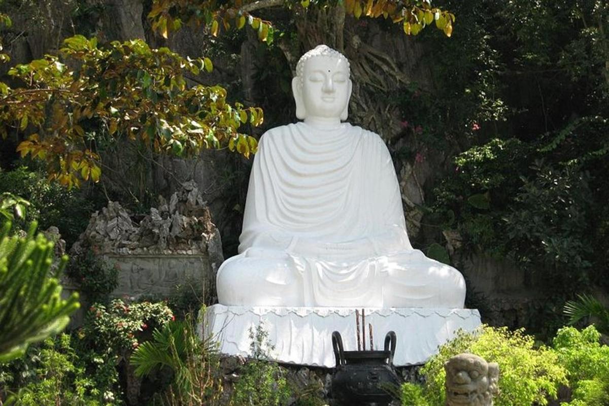 o statuie albă mare stând într-o grădină