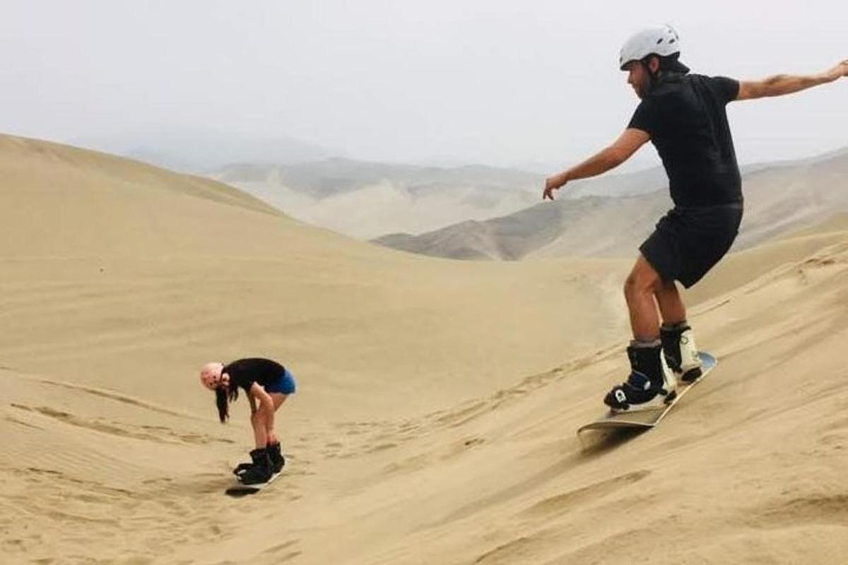 un uomo che scende su uno skateboard lungo una duna di sabbia