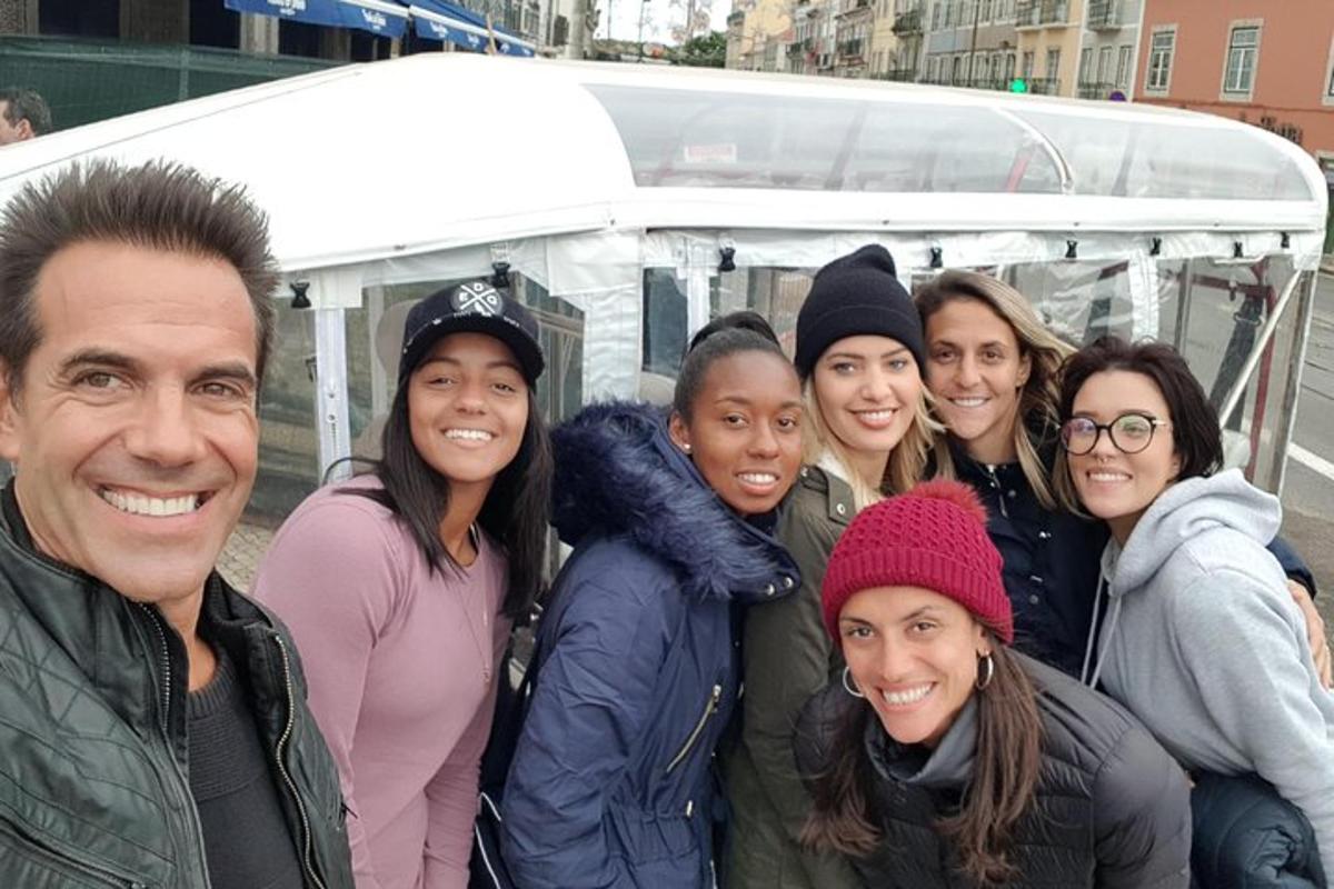 um grupo de pessoas em pé na frente de um ônibus