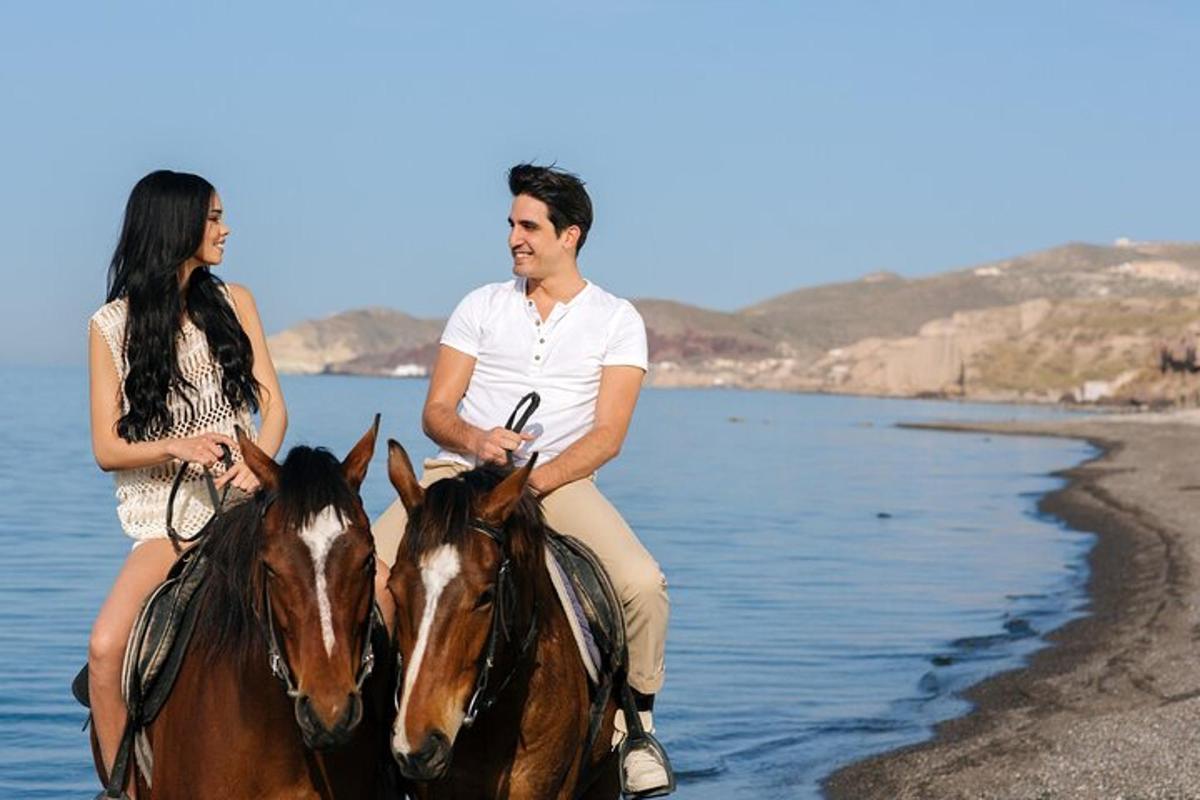 a man and a woman riding horses on the beach