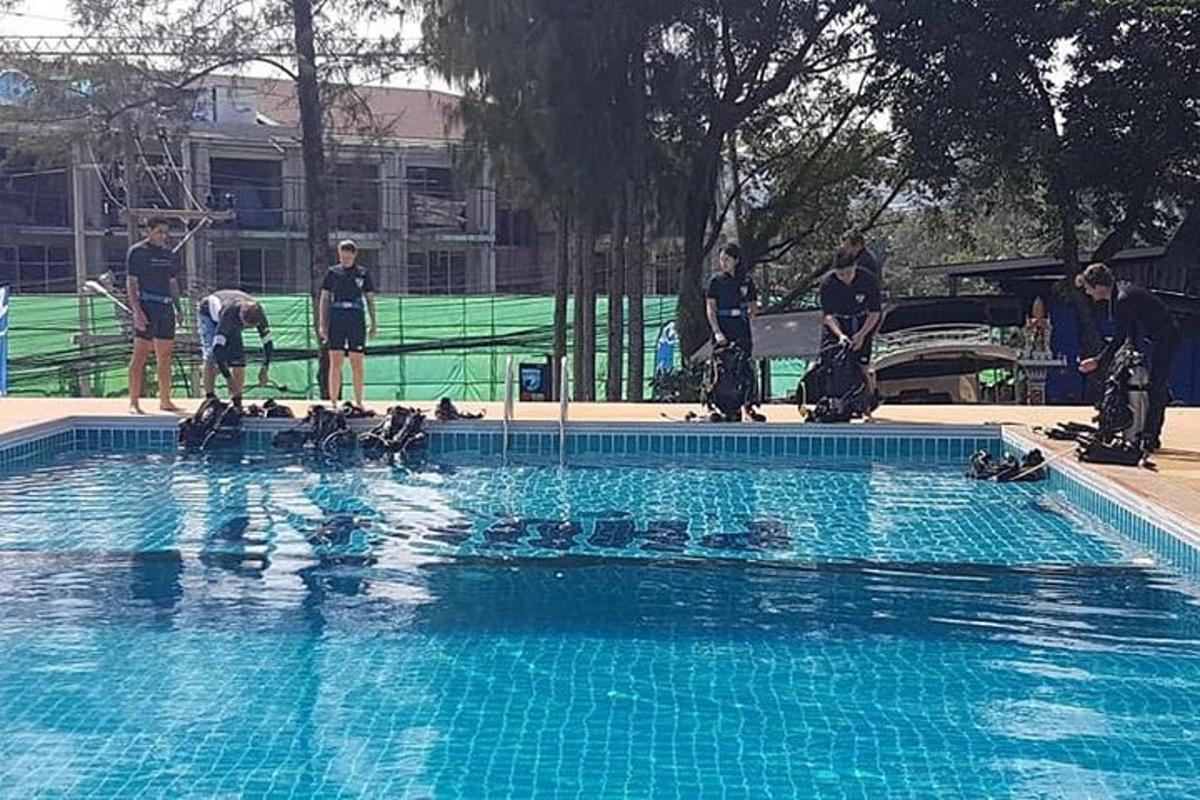 a group of people standing around a swimming pool