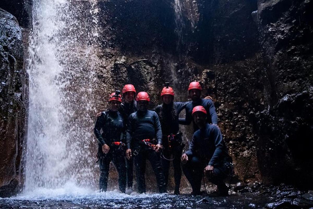 a group of people standing in front of a waterfall