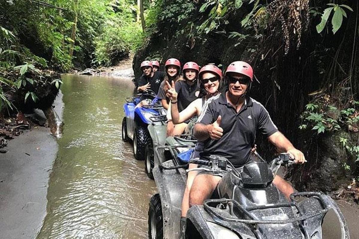 un grup de oameni care călătoresc pe ATV-uri într-un râu