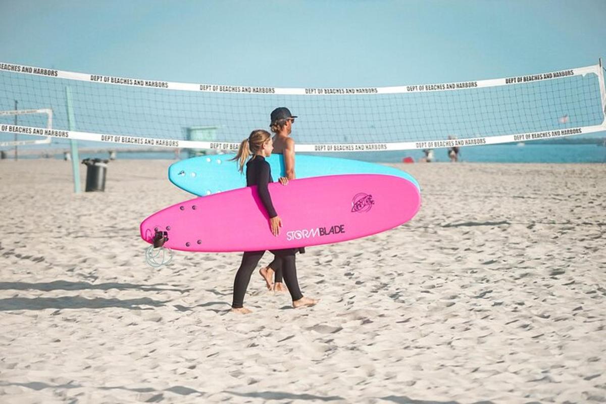 twee mensen staan op het strand met surfplanken