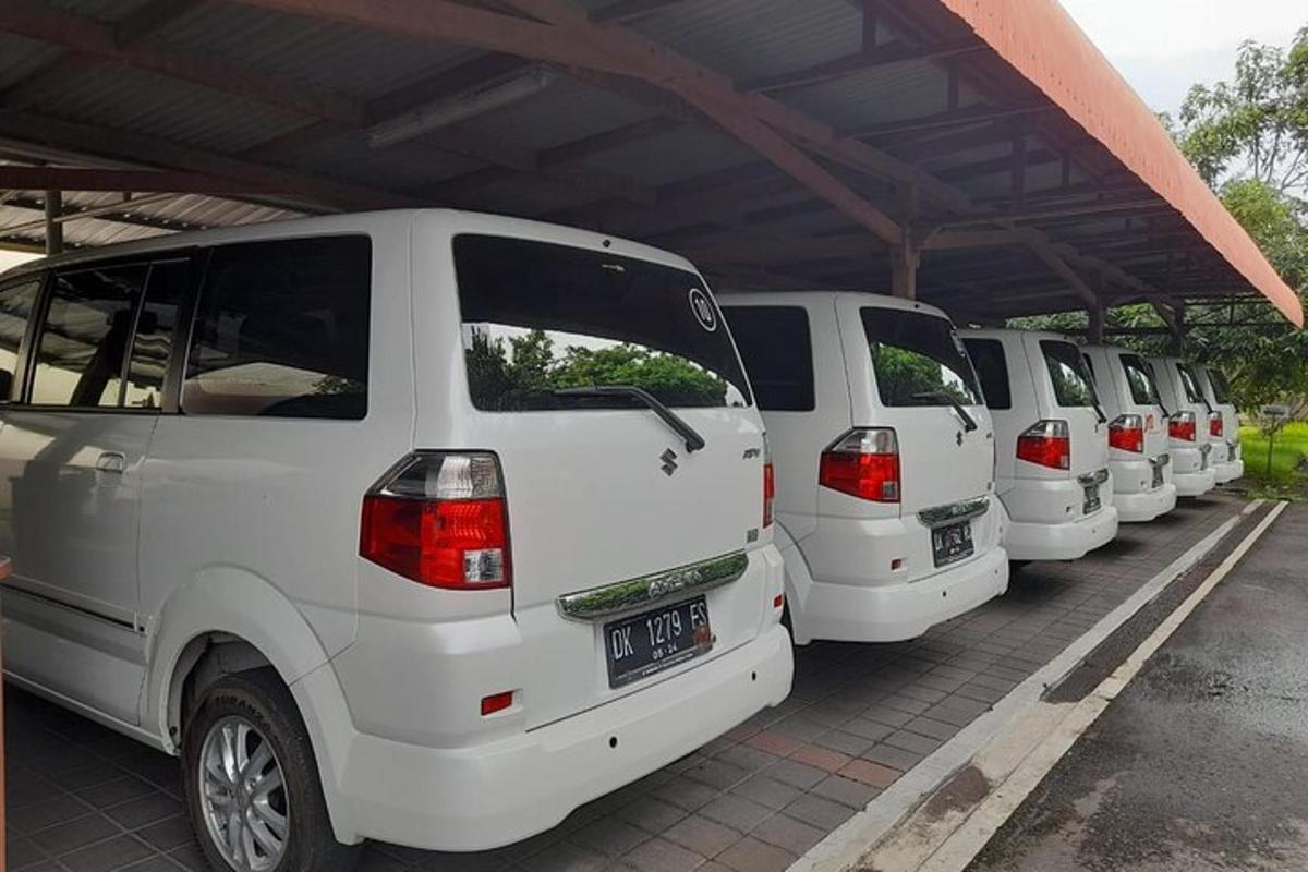 uma fileira de vans brancas estacionadas em um estacionamento