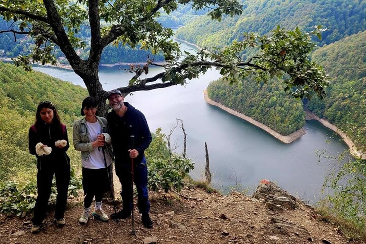 un gruppo di persone in piedi su una collina vicino a un fiume