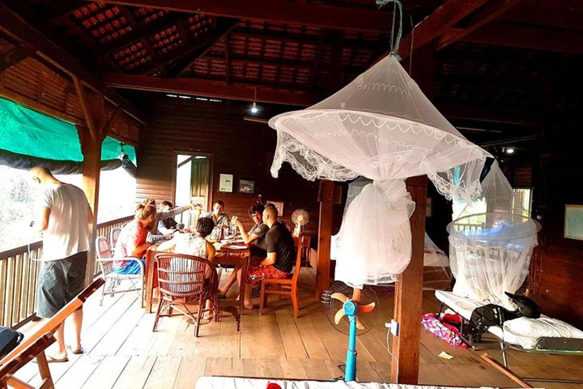 sekumpulan orang duduk di meja di bawah payung