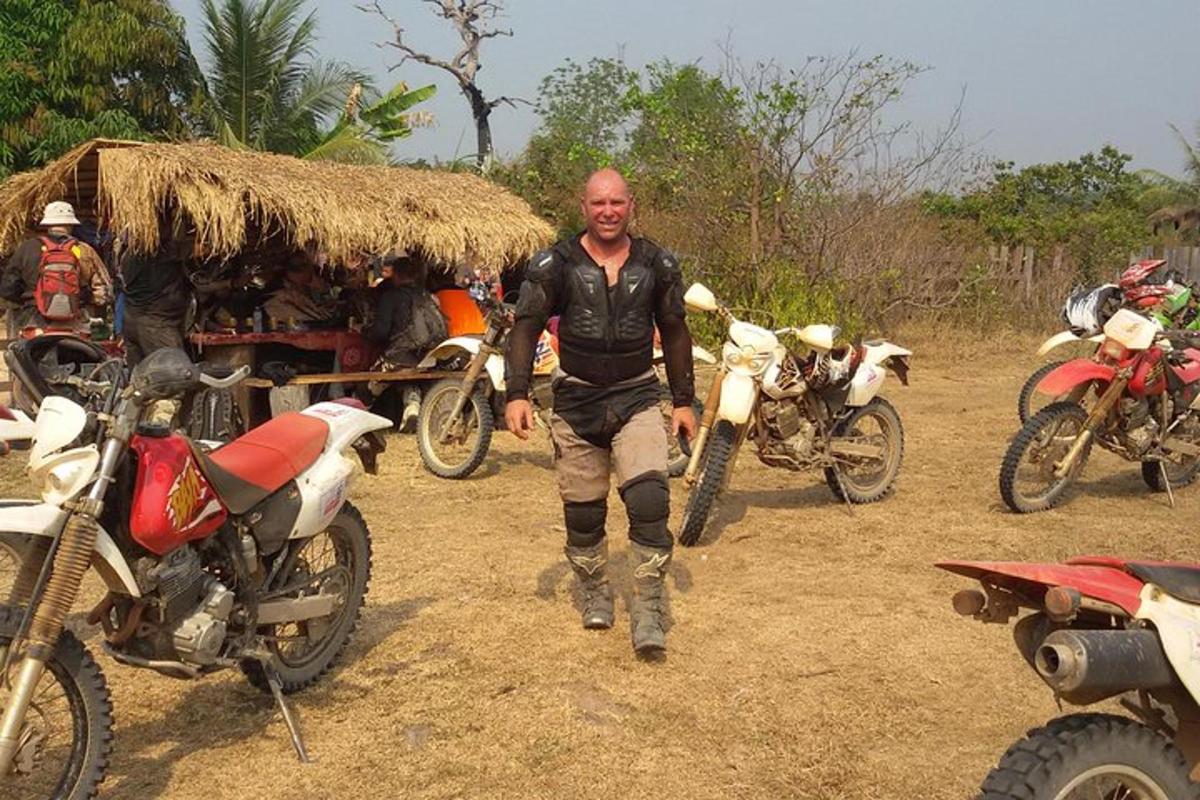 seorang lelaki berdiri di hadapan sekumpulan motosikal