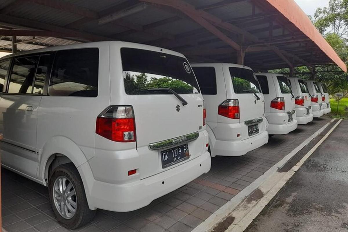 uma fileira de vans brancas estacionadas em um estacionamento