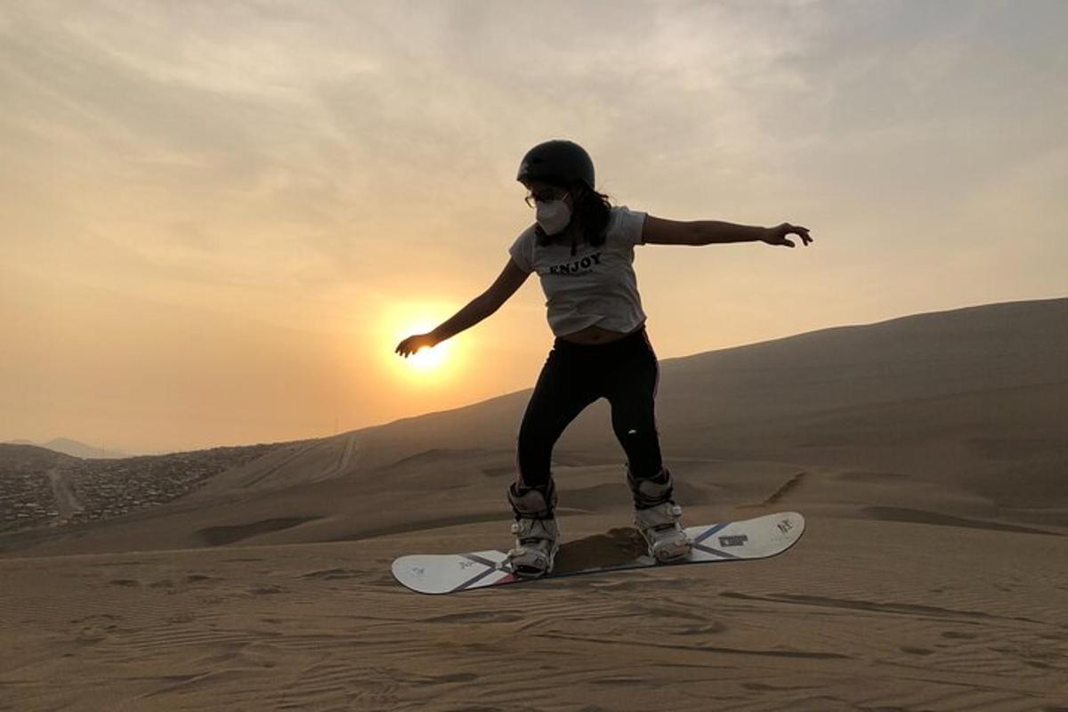 una persona montando una tabla de snowboard en el desierto