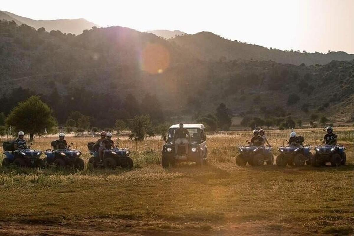 Egy csoport ember ATV-ken és egy dzsipen egy mezőn
