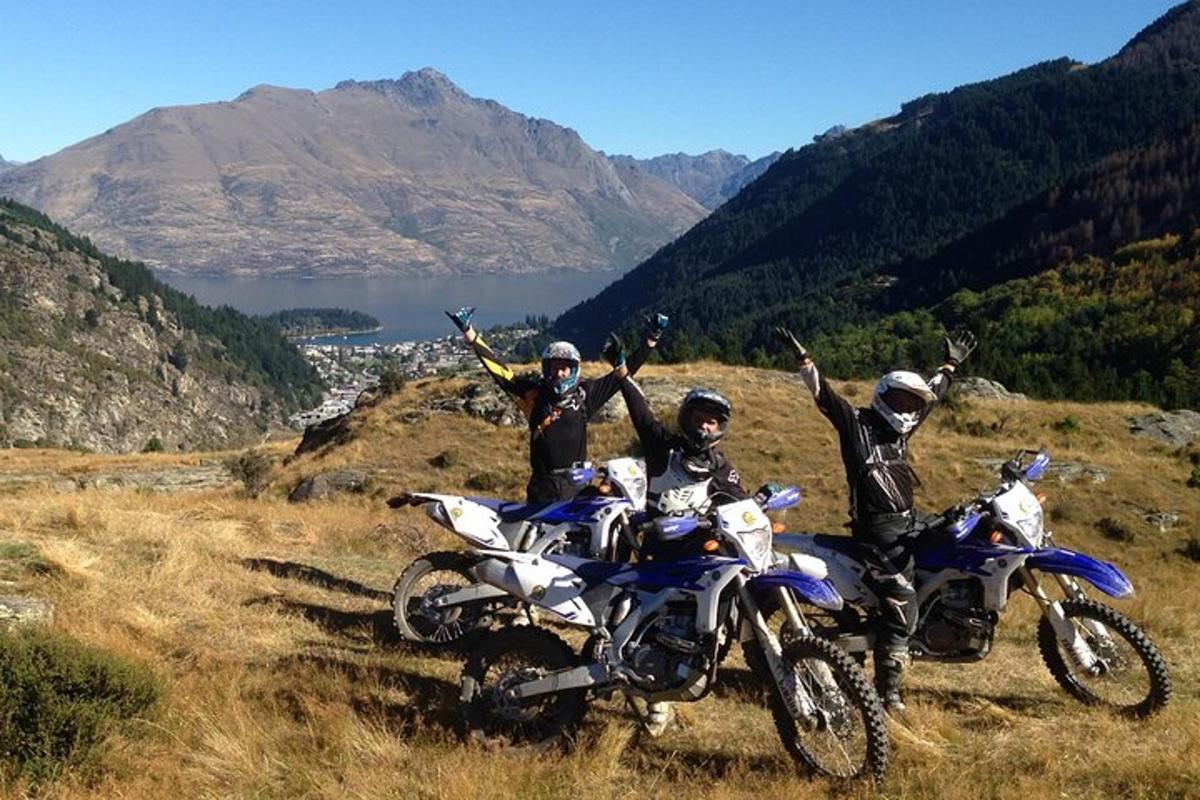 trois personnes à moto sur une colline avec les bras levés