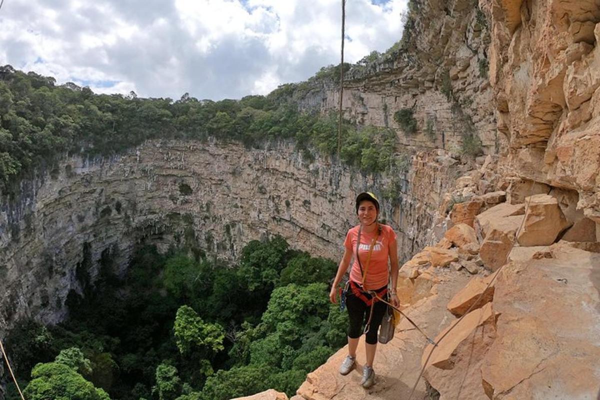 a woman standing on the side of a cliff