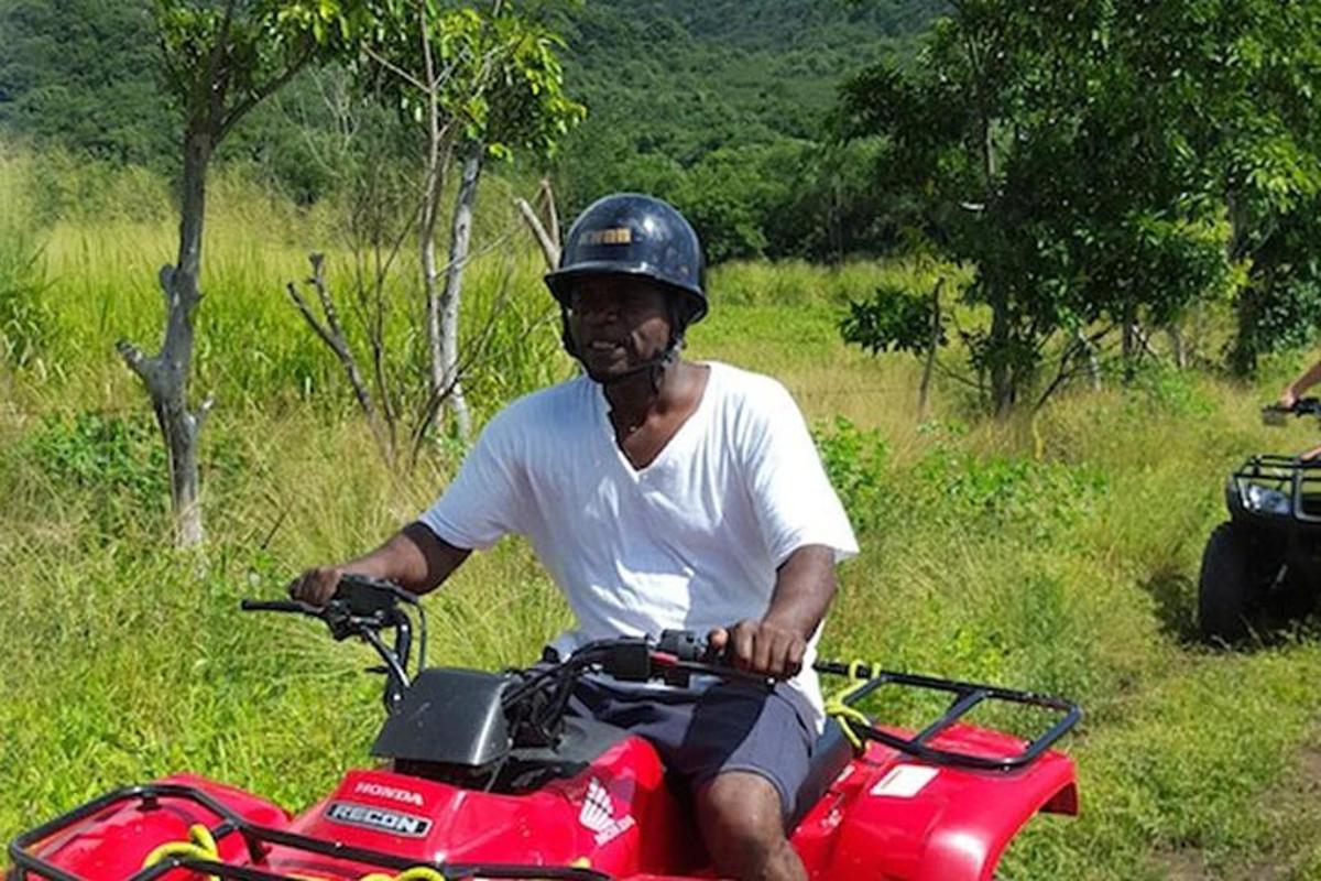 a man wearing a helmet riding a red quad bike