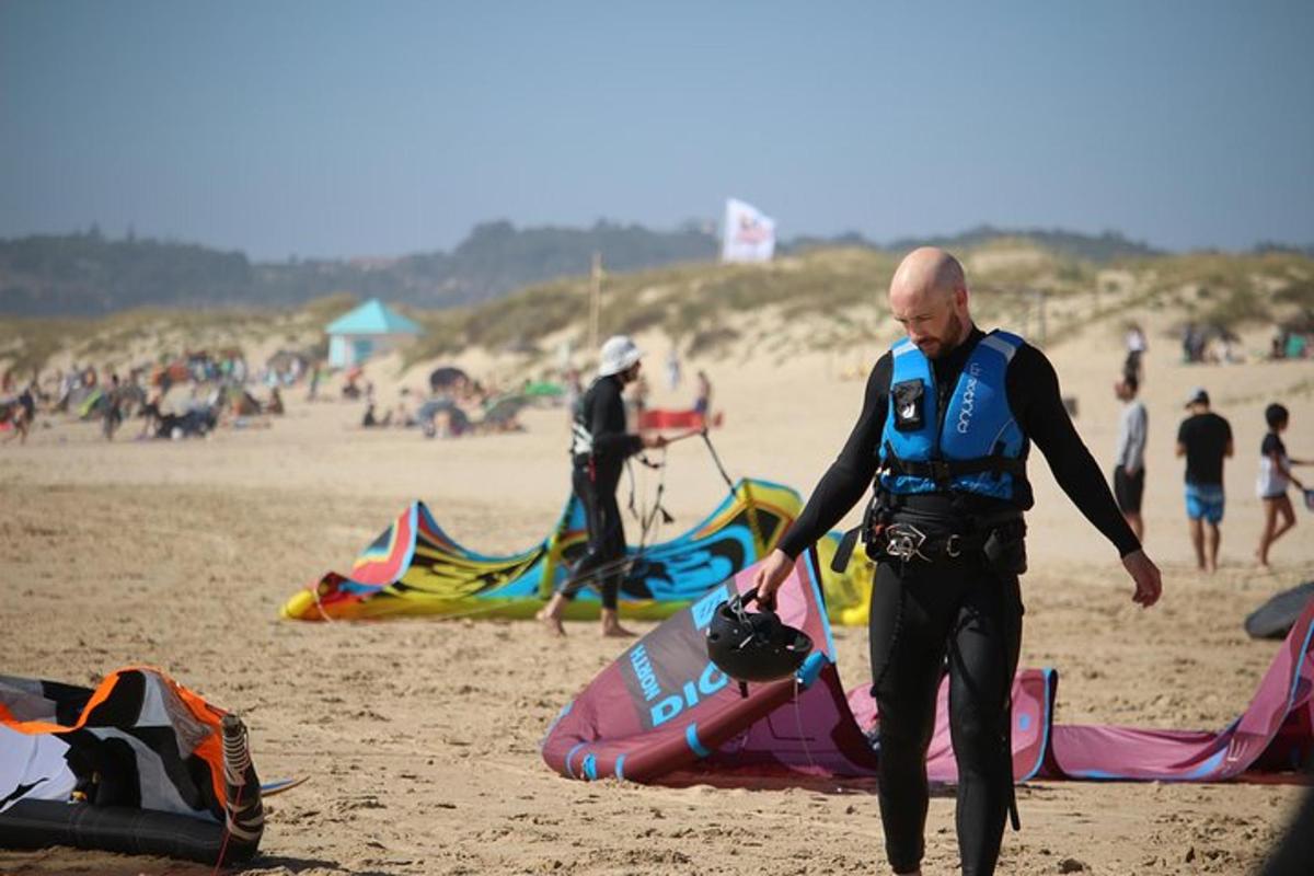 a man is walking on a beach with kites