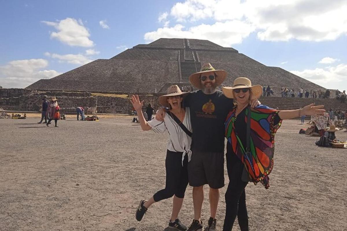 three people standing in front of a pyramid