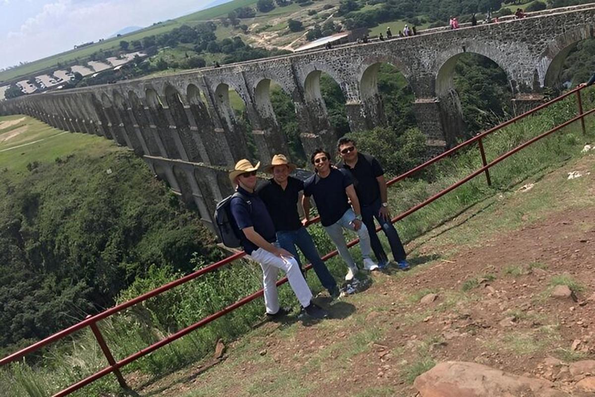 a group of people standing in front of a bridge