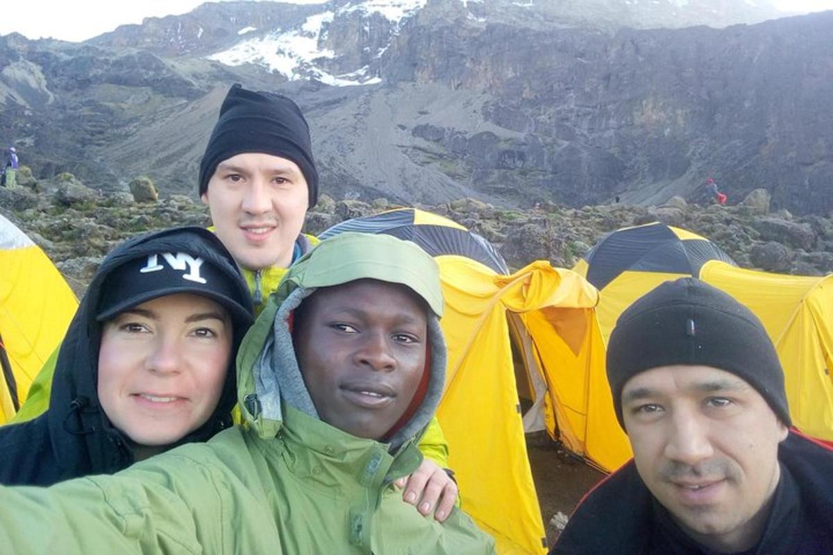 a group of three men standing in front of tents