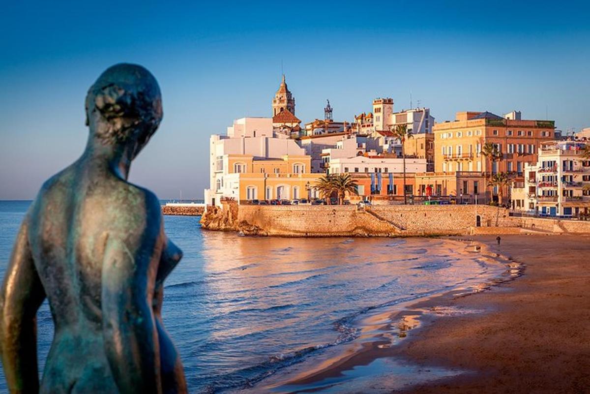 una estatua en la playa con una ciudad al fondo