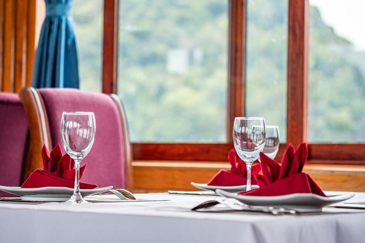 a table with two wine glasses and red napkins