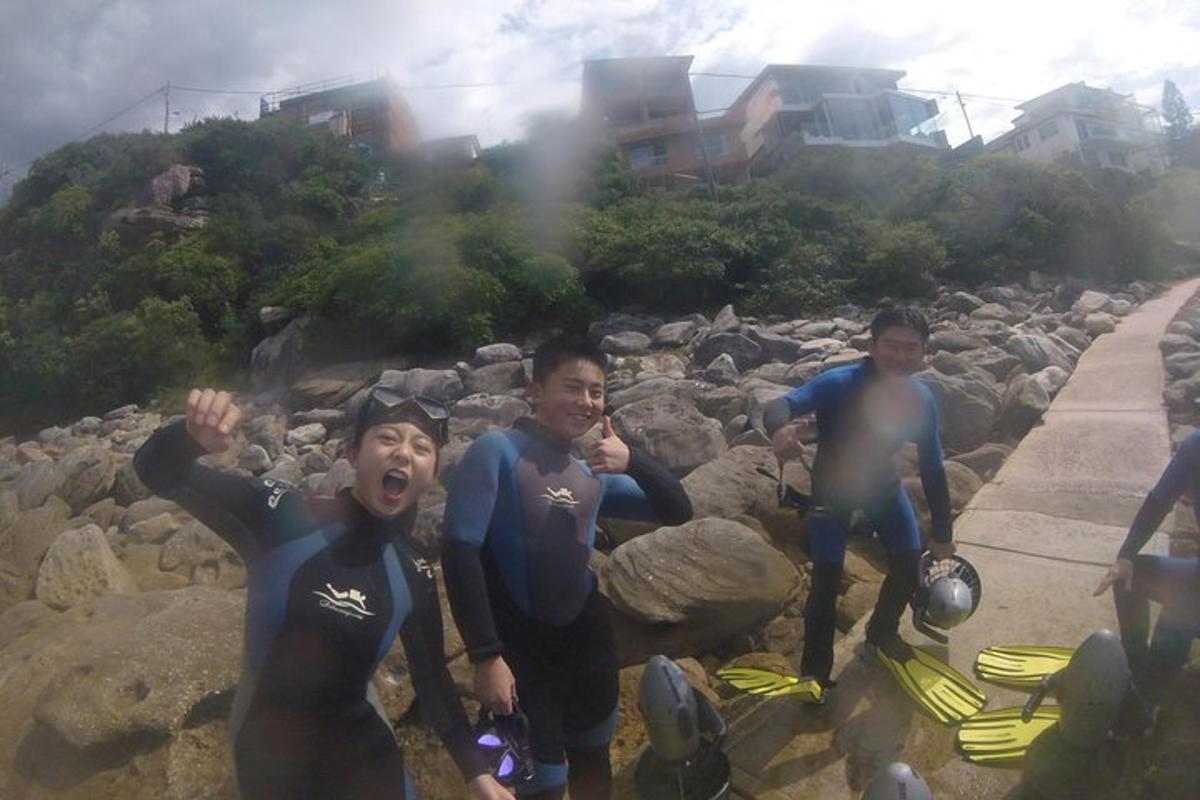 Un grupo de hombres con trajes de neopreno de pie sobre las rocas
