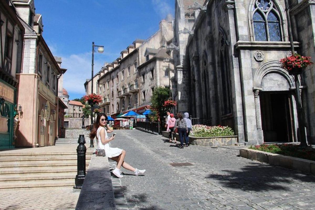 žena u bijeloj haljini sjedi na stupu na ulici