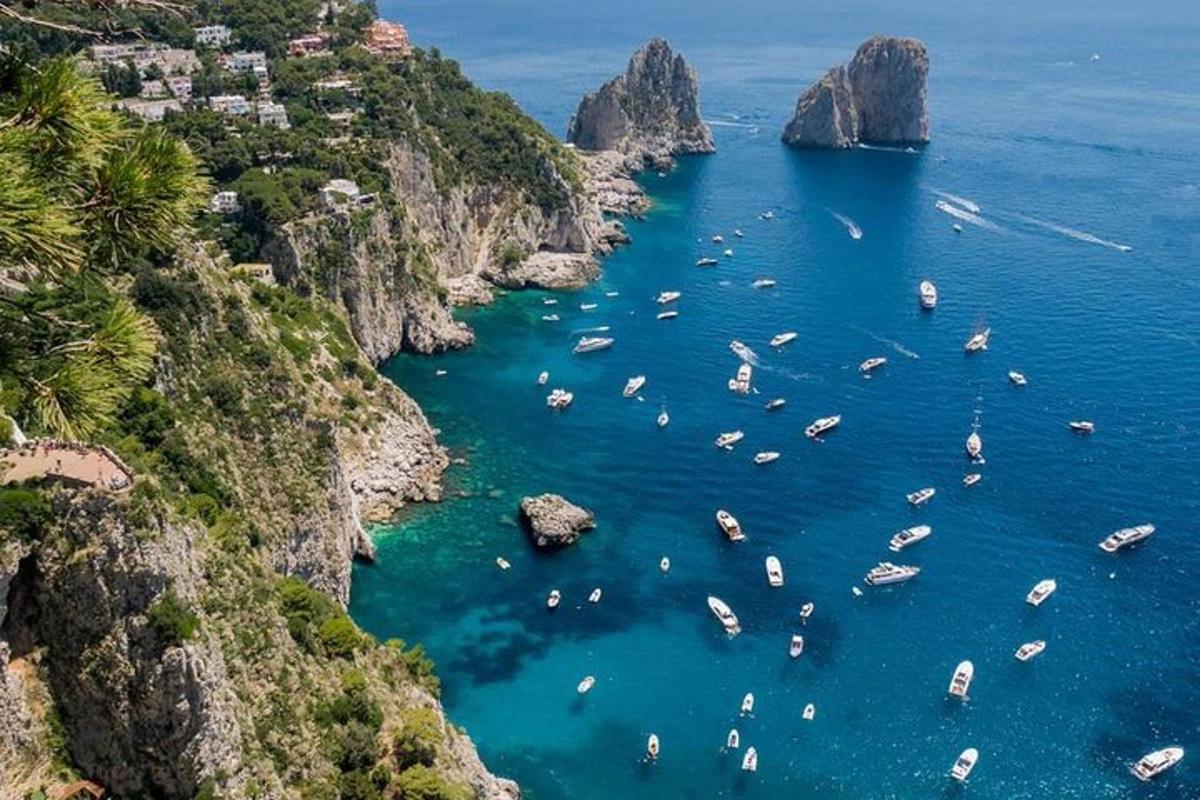 un gruppo di barche in acqua vicino alle scogliere