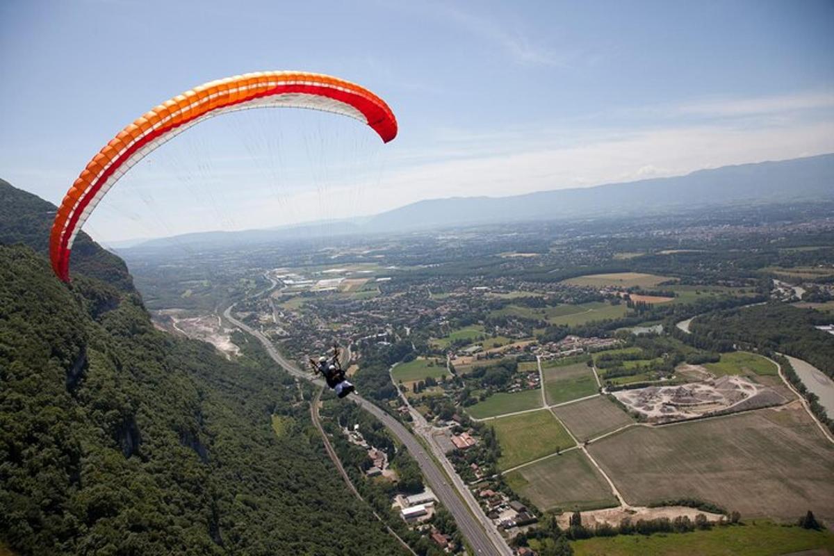 a person in a parachute flying over a city